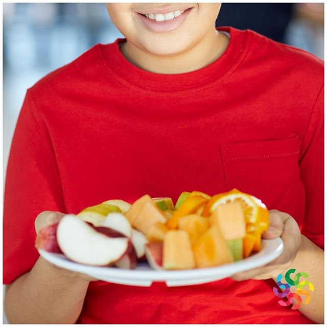 Smiling child holding a fruit plate