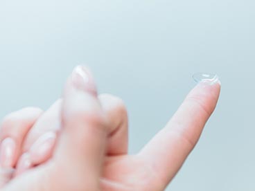 Hand with a contact lens on the fingertip