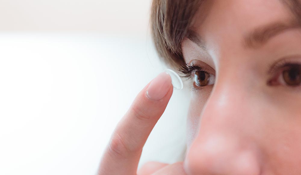 Femme mettant une lentille sclérale