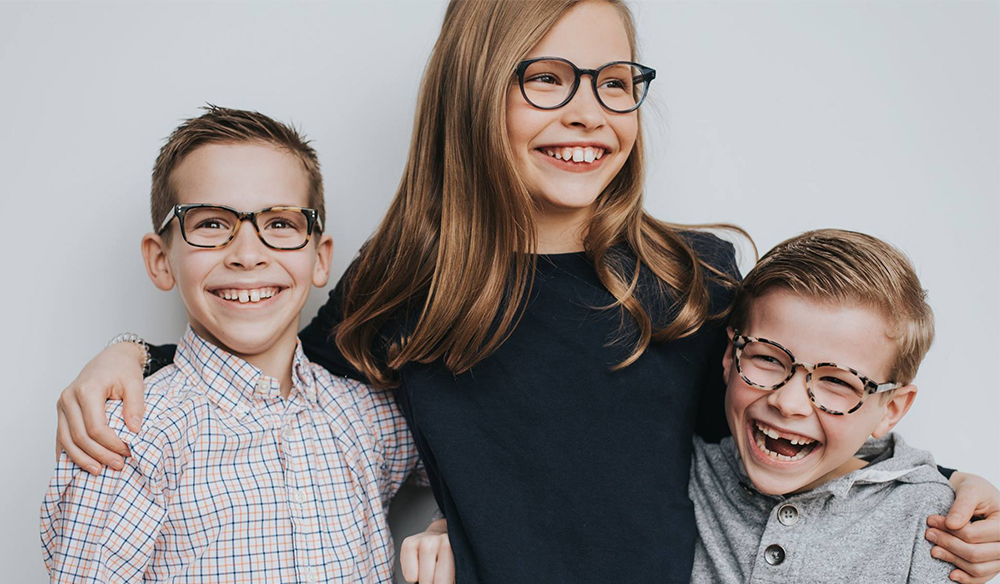 Three smilling kids with glasses